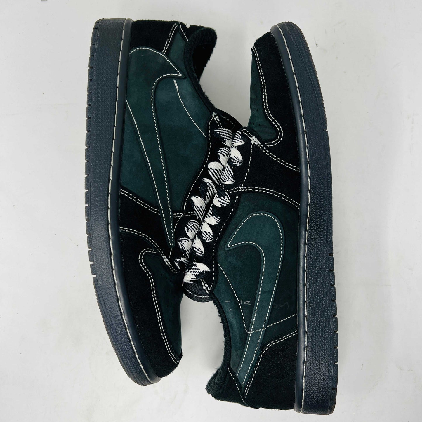 A side view of the Jordan 1 Retro Low OG SP Travis Scott Black Phantom sneaker in black and dark gray with white stitching, size 9.5, displayed on a box with clean uppers and extra laces. A blue sticker shows A2301, with the box label priced at $945.