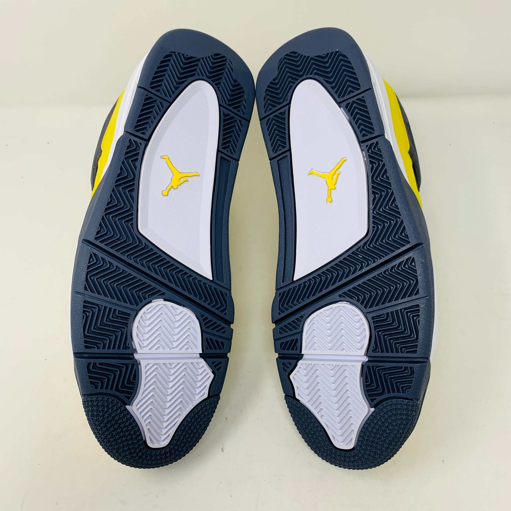 Jordan 4 Lightning sneakers with yellow and black colorway and unique lightning bolt accents.