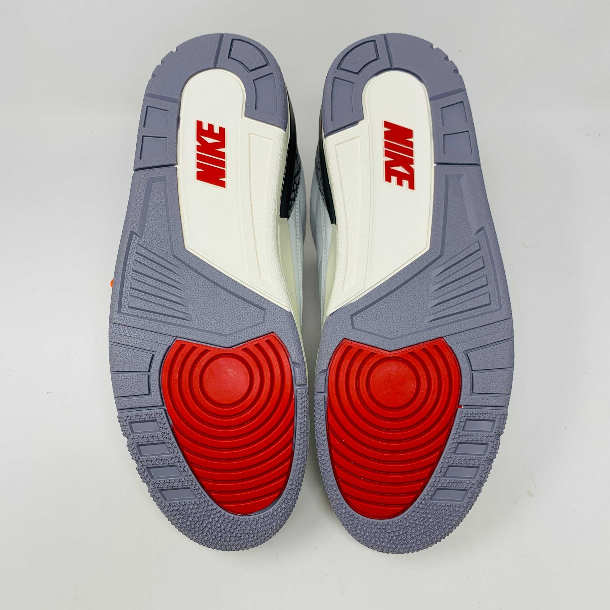 Jordan 3 Retro White Cement Reimagined sneakers with red, white, and gray outsoles.
