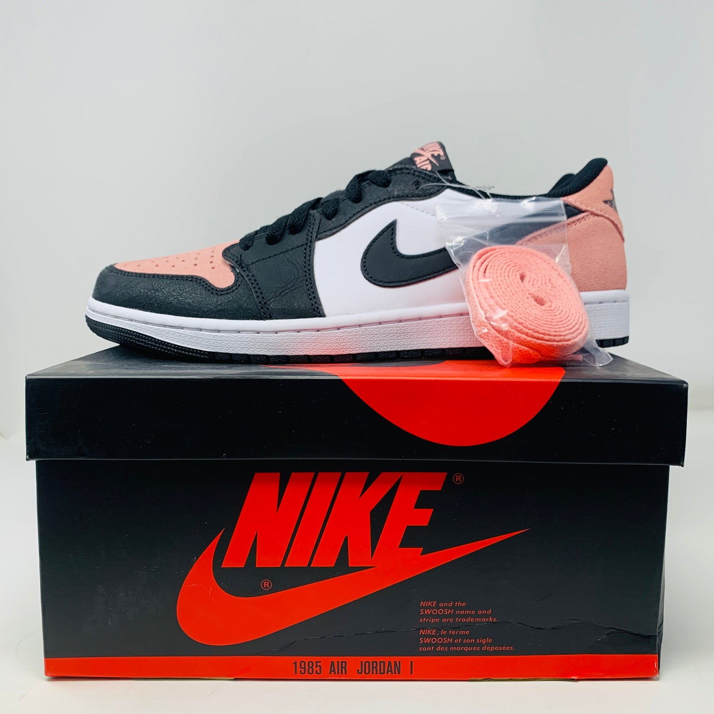 Jordan 1 Low Bleached Coral sneakers with extra pink laces on Nike box, 2022.