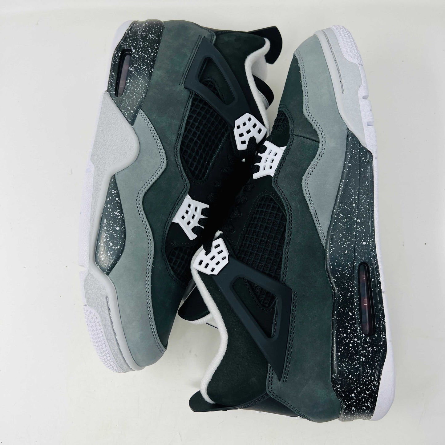 On top of a shoebox sits the brand-new Jordan 4 Retro Fear (2024), a stylish sneaker by Jordan. Its black and gray color scheme, black mesh accents, white midsole, and speckled heel details make it a must-have for 2024.