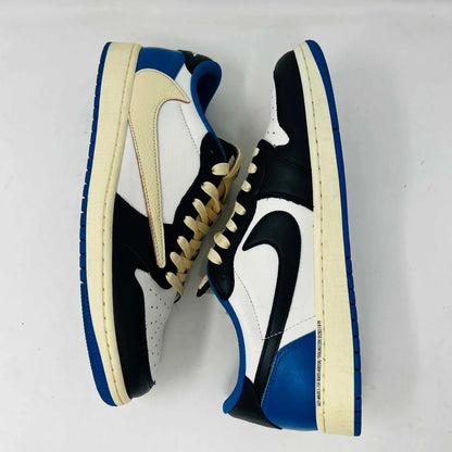 The Jordan 1 Retro Low OG SP Fragment x Travis Scott sneaker, with a blue, black, and white color scheme, sits on a Nike box. Two extra shoelace pairs in black and pink are included in clear bags to keep your look fresh with authentic VNDS style.