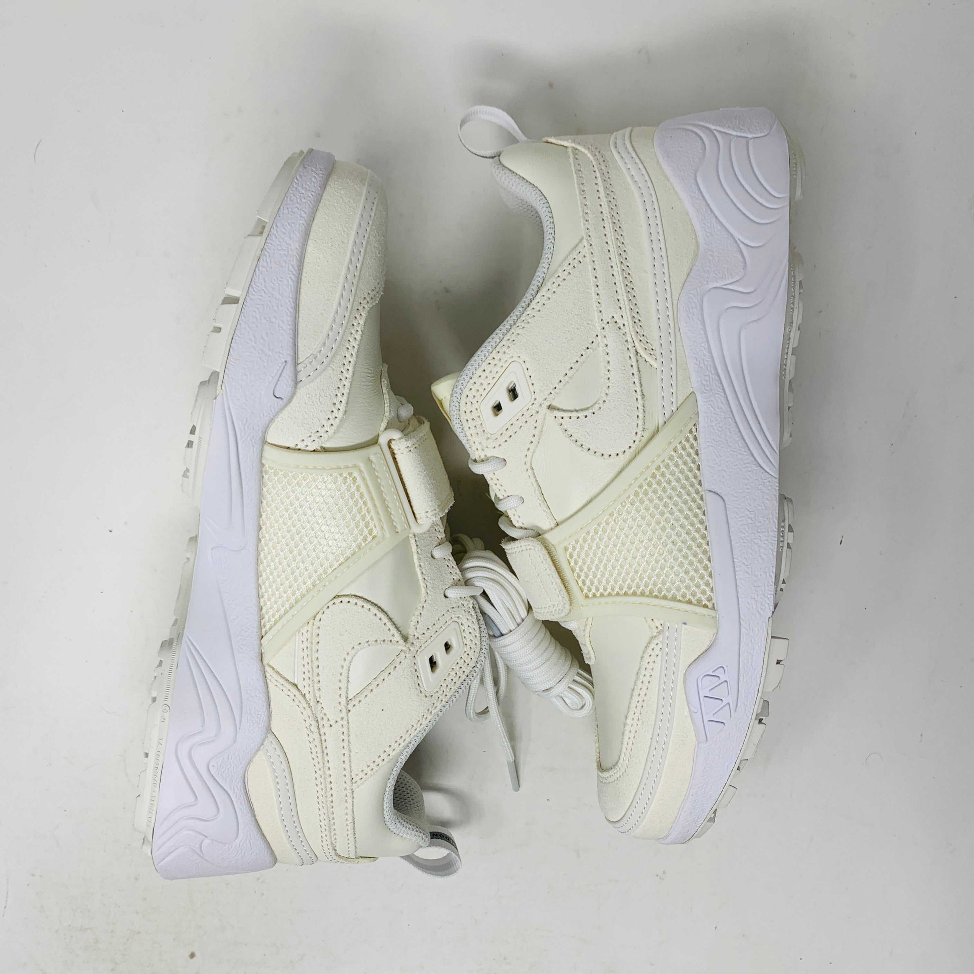A pair of brand new, 100% authentic Nike Zoom Field Jaxx SP Travis Scott Sail sneakers feature a white colorway with a textured design and lace-up closure. The shoes, shown on a white background, have a thick sole and combine smooth and perforated panels.