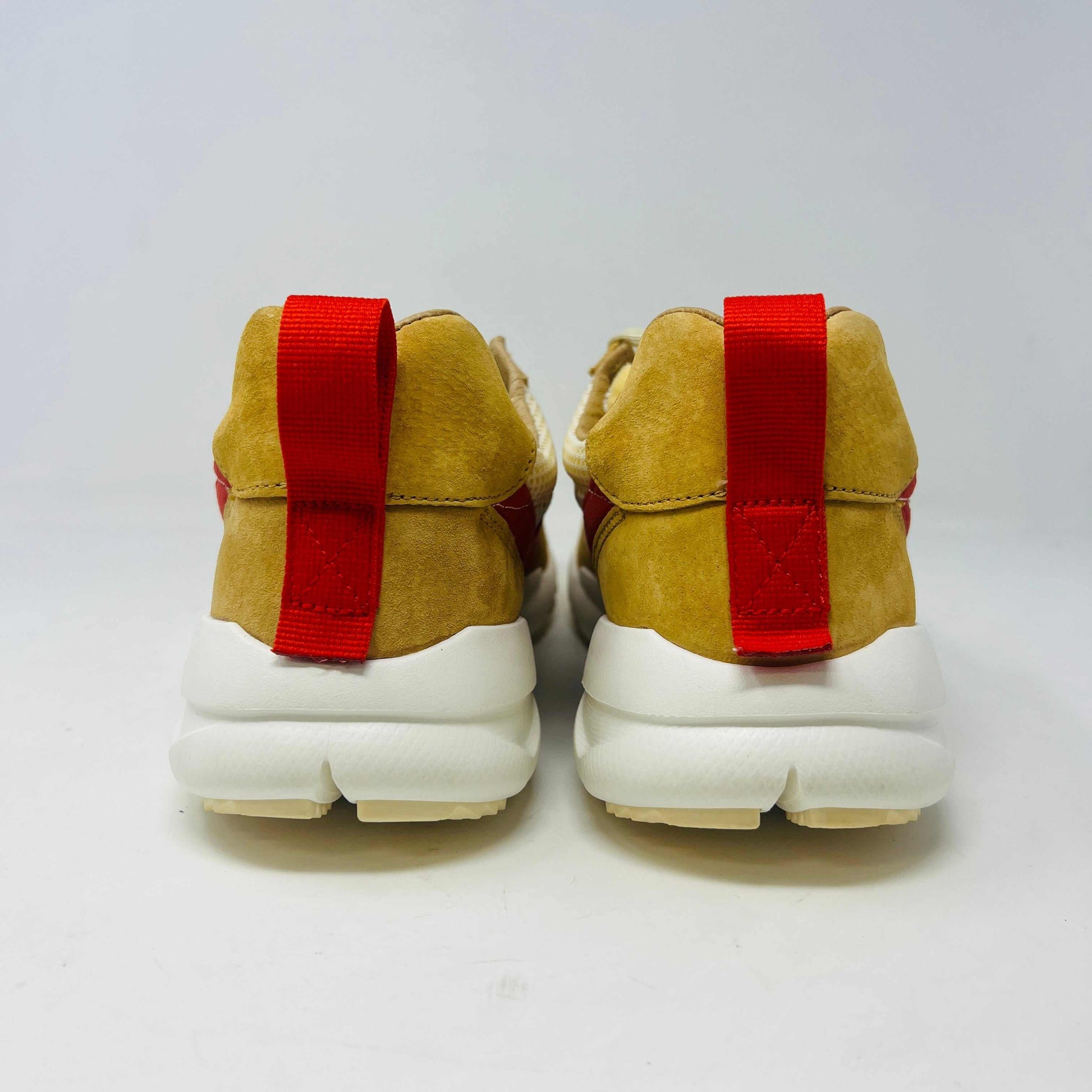 The NikeCraft Mars Yard Shoe 2.0 by Tom Sachs Space Camp features white mesh, tan suede accents, red Nike logos on the tongues, red heel pull tabs, and white laces. This 100% authentic sneaker is perfect for elevating any outfit with style.