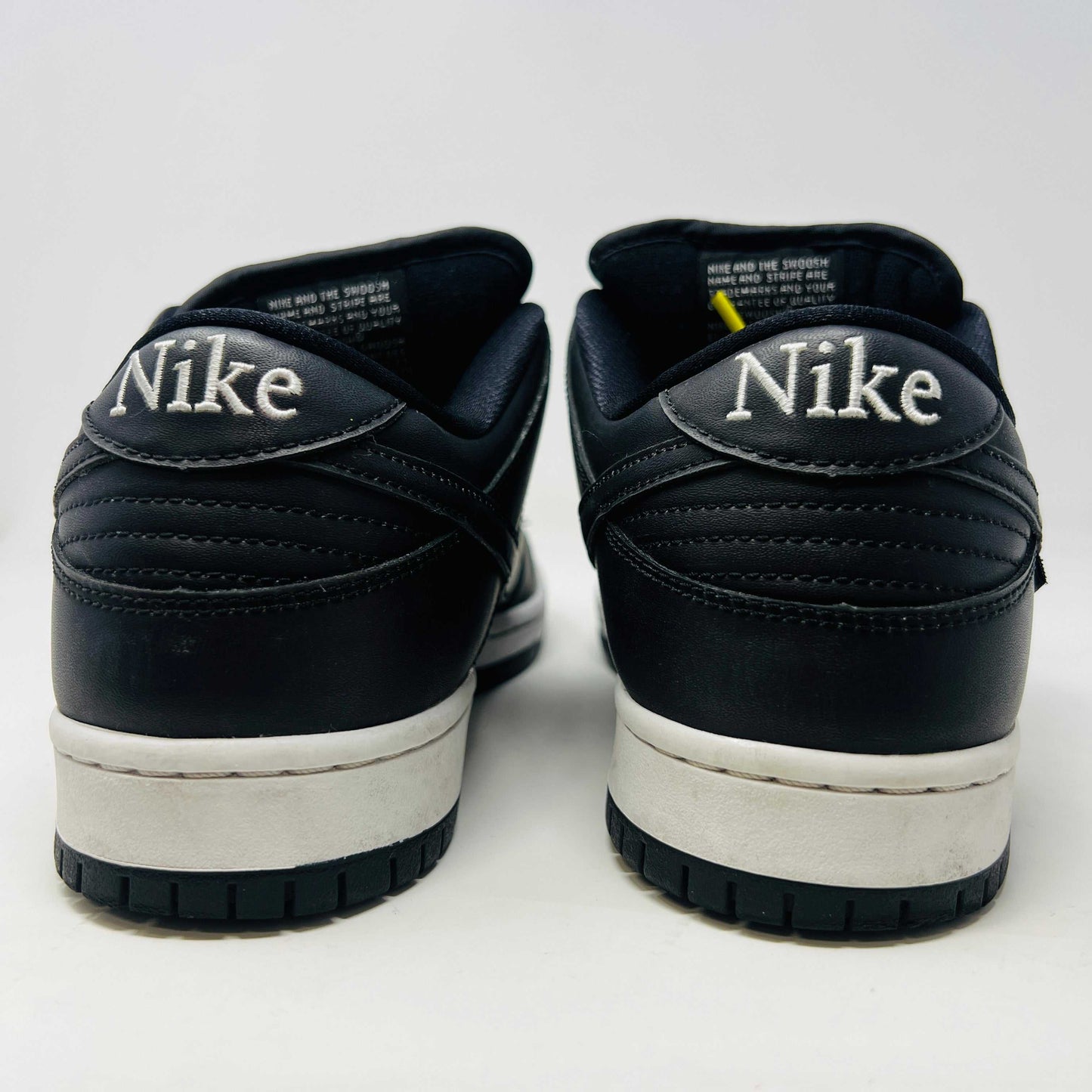 Nike SB Dunk Low Civilist sneakers, black with white soles and yellow tongue details, showcased on a white backdrop. They blend style and comfort effortlessly, making them a standout in 2020 sneaker collections.