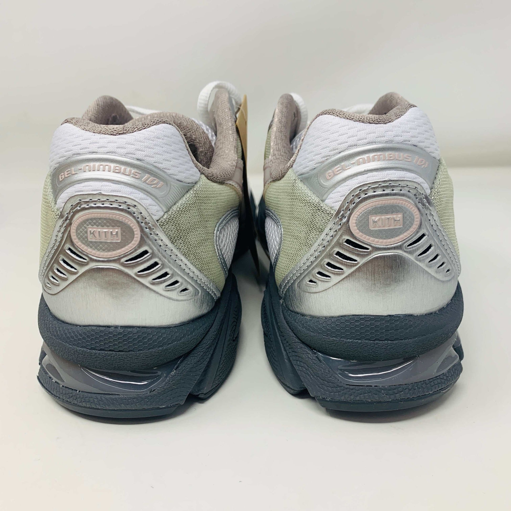 The ASICS Gel-Nimbus 10.1 Kith White Morganite features white, gray, and light pink tones displayed on a shoebox. Includes two sets of laces: one brand new in white with black specks and one plain beige, sealed in plastic bags, ready for 2024.