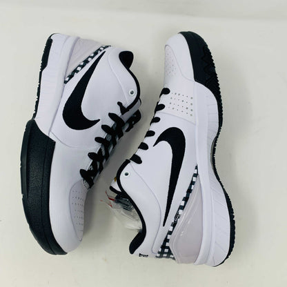 The Nike Kobe 4 Protro Mambacita Gigi shoe, featuring a black swoosh, black accents, and a checkered heel pattern, is displayed on a white box with a gold Nike logo. The box also includes extra laces.