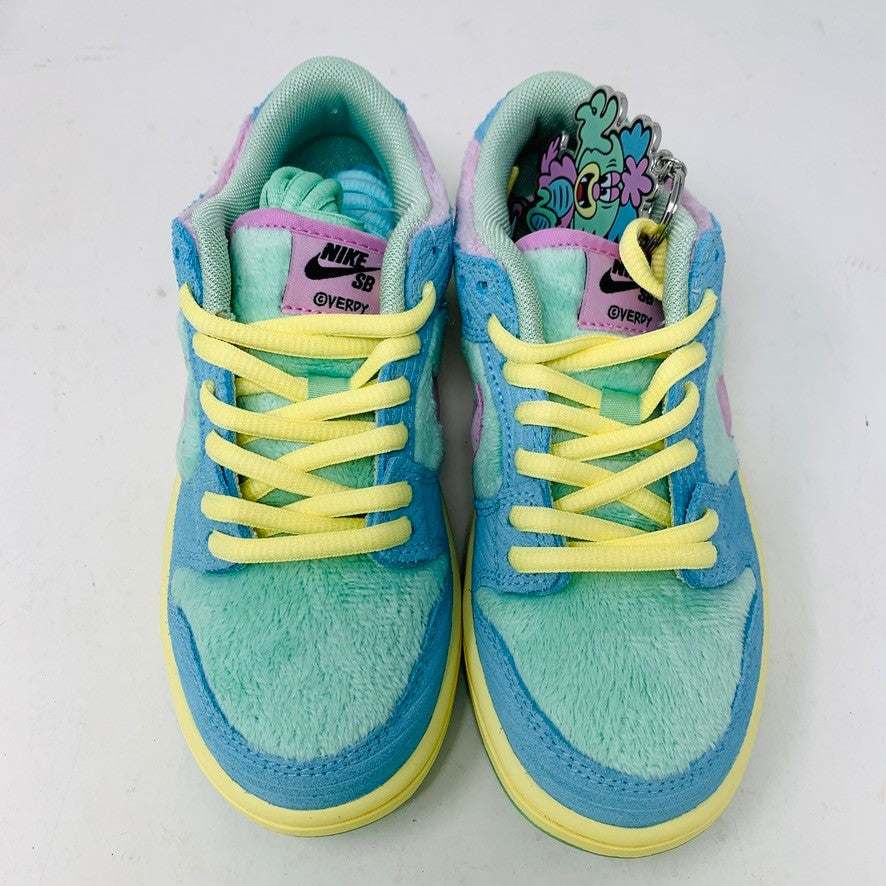 The 100% authentic Nike SB Dunk Low Verdy Visty (PS) sneaker showcases blue, pastel yellow, pink, and mint green accents with textured fabric and a pink swoosh. It is displayed atop a white Nike SB shoebox.