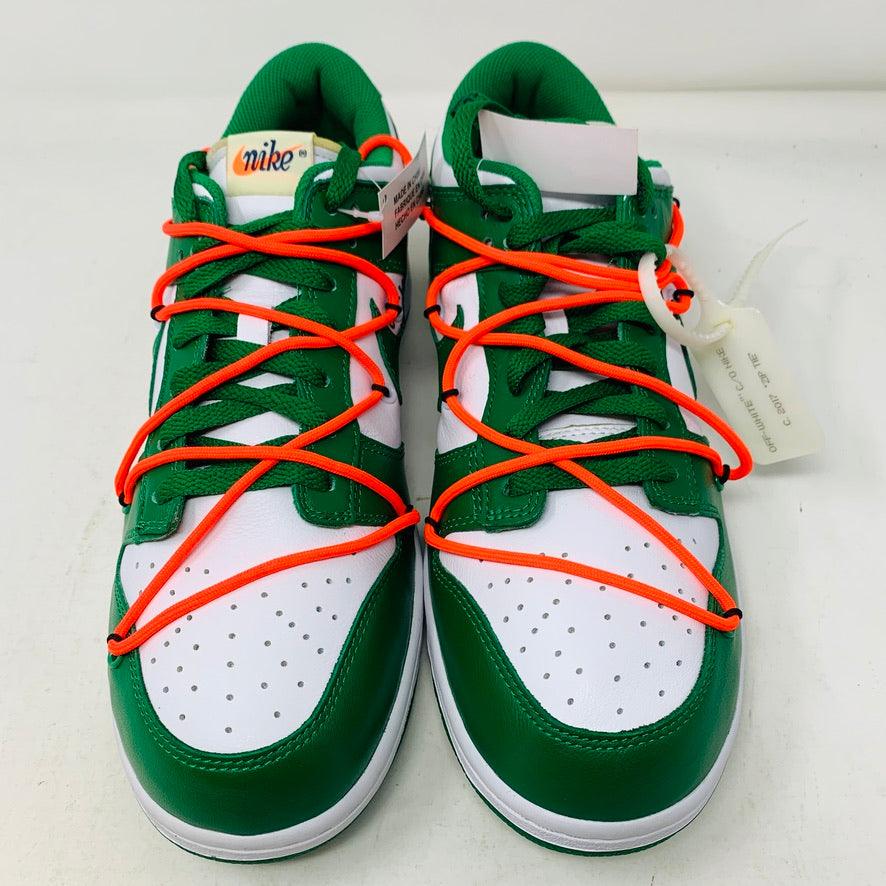 The Nike Dunk Low Off White Pine Green sneaker, accented with bright orange laces, rests on a shiny silver box. This authentic 2019 release by Nike boasts a sleek white tag, highlighting its new allure.