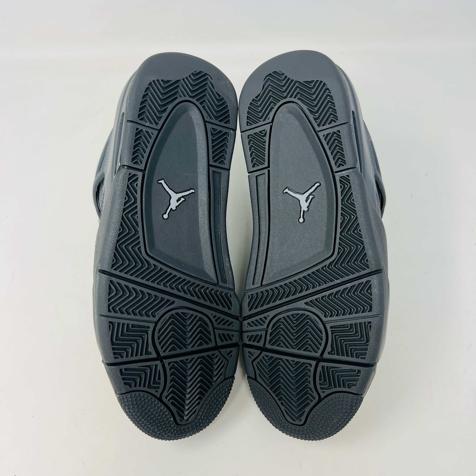 The Jordan 4 Retro SE Paris Olympics Wet Cement (GS), a brand-new gray sneaker, sits atop its pristine box. Featuring mesh and suede elements, it has a visible air unit in the midsole and a rubber outsole, poised to make an impression in 2024 against a plain white background.