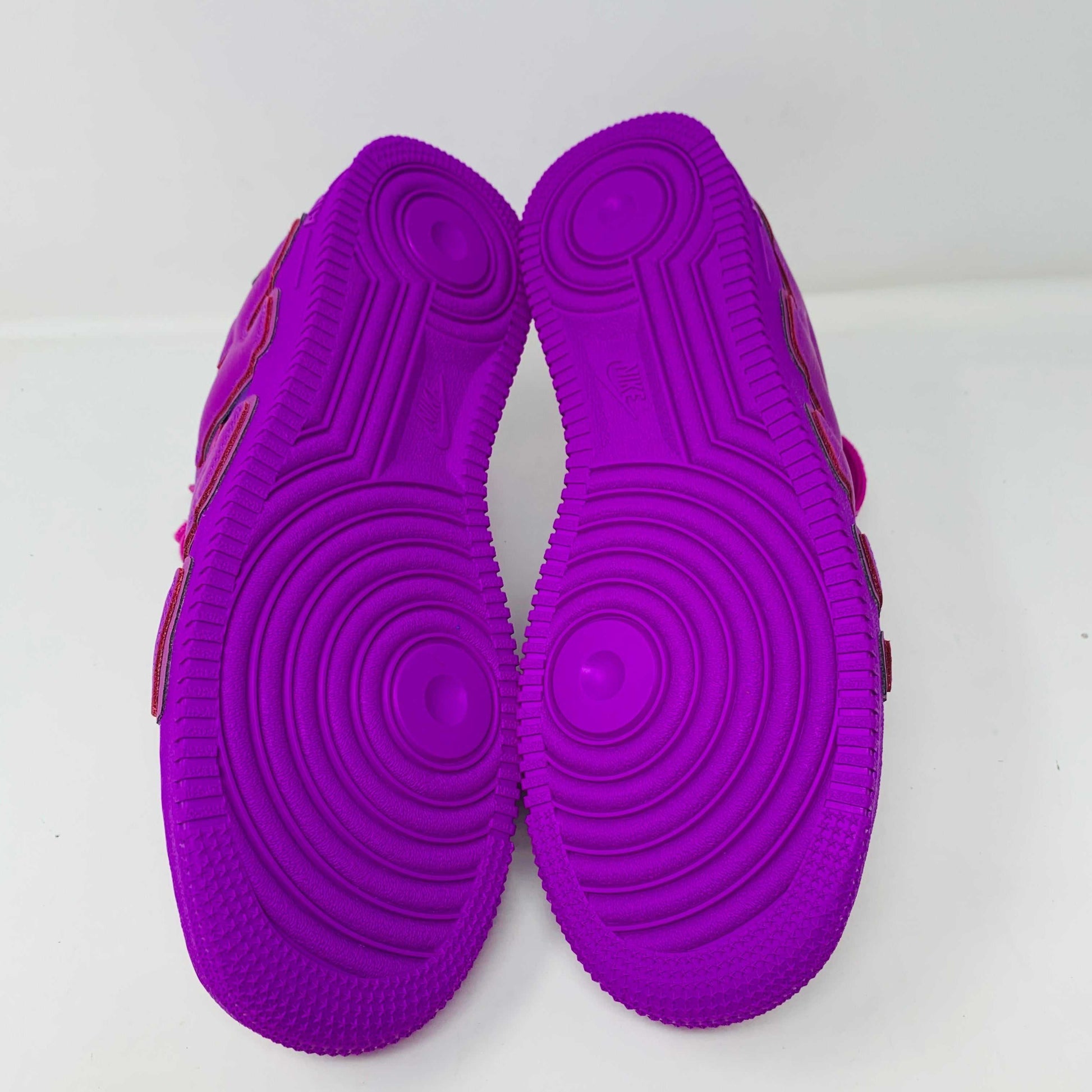 The Nike Air Force 1 Low Cactus Plant Flea Market Fuchsia Dream sneaker, vibrant pink with oversized SUN lettering, boldly sits on a black box featuring the iconic white swoosh. This brand new, 100% authentic pair includes extra laces and is presented against a plain white background.