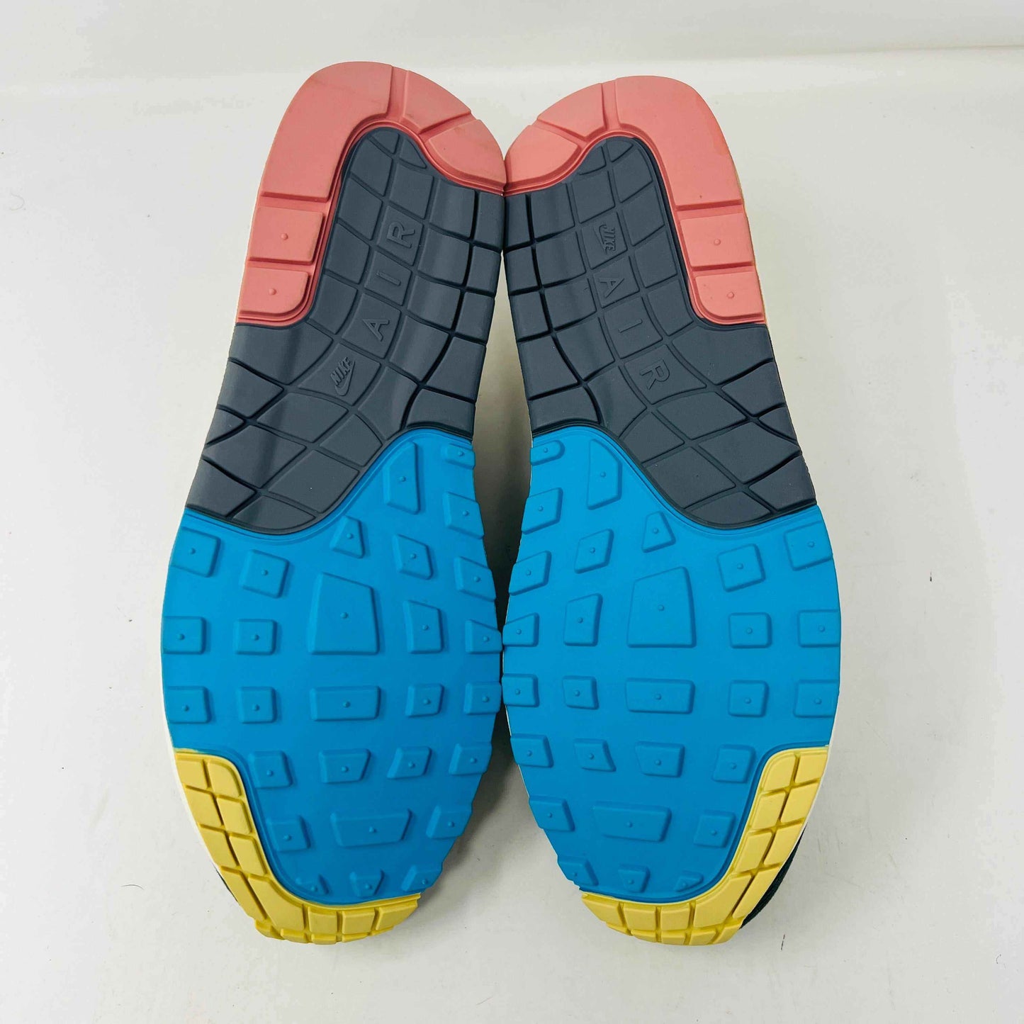 Nike Air Max 1/97 SW Sean Wotherspoon sneakers are displayed on a red Nike box, with authentic extra blue and yellow laces in plastic bags in front. The brand-new shoes feature a wave-like design with vibrant colors.