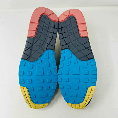 Nike Air Max 1/97 SW Sean Wotherspoon sneakers are displayed on a red Nike box, with authentic extra blue and yellow laces in plastic bags in front. The brand-new shoes feature a wave-like design with vibrant colors.