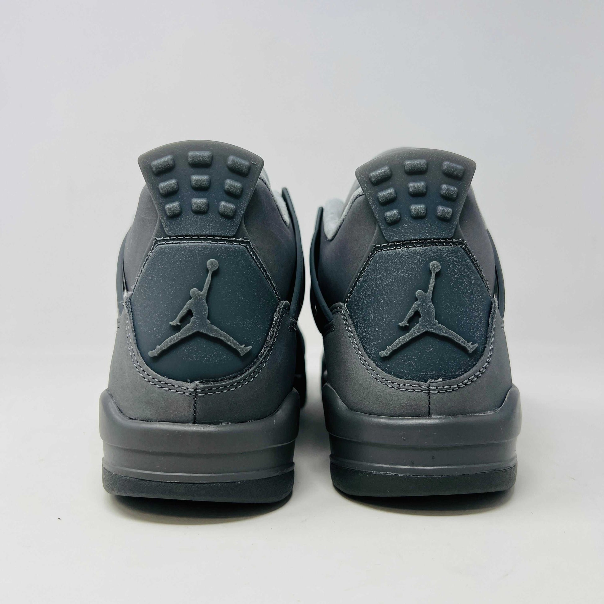 The Jordan 4 Retro SE Paris Olympics Wet Cement (GS), a brand-new gray sneaker, sits atop its pristine box. Featuring mesh and suede elements, it has a visible air unit in the midsole and a rubber outsole, poised to make an impression in 2024 against a plain white background.