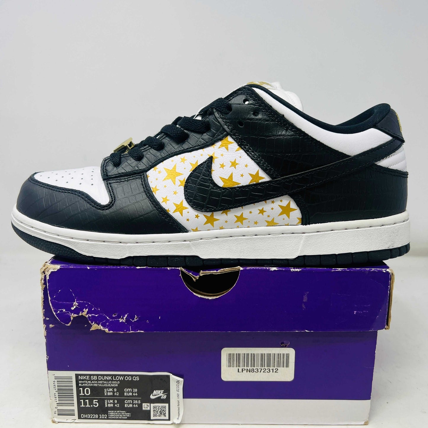Nike SB Dunk Low Supreme Stars Black 2021 sneaker with black and white upper and gold star pattern on purple box