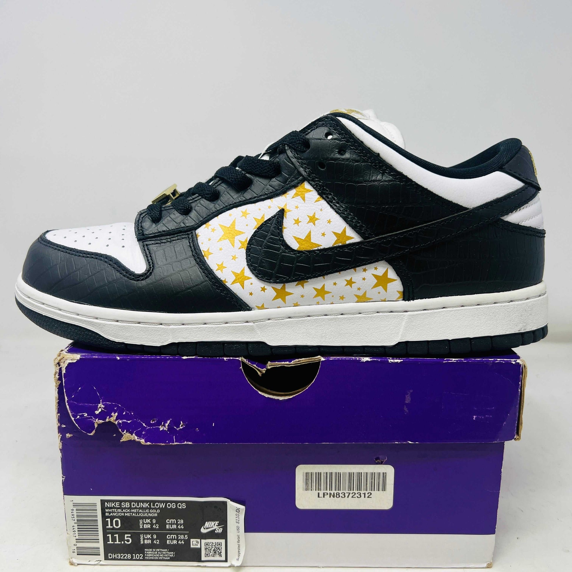 Nike SB Dunk Low Supreme Stars Black 2021 sneaker with black and white upper and gold star pattern on purple box