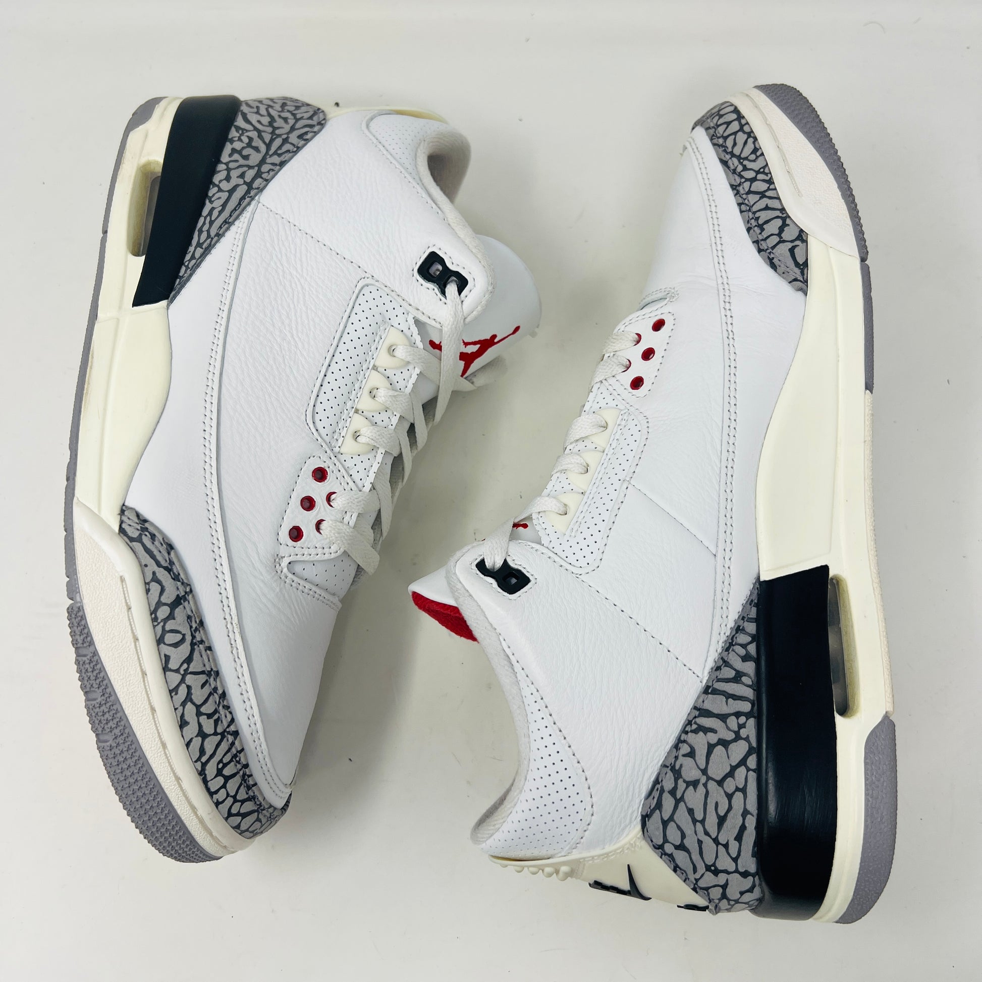 Jordan 3 Retro White Cement sneakers on Nike box, 2023 edition.