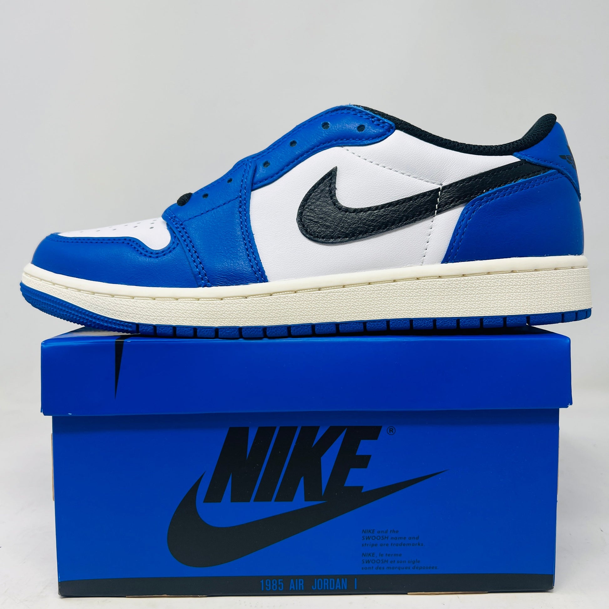 Jordan 1 Retro Low OG Game Royal sneakers on blue Nike box, brand new, 2024 release.