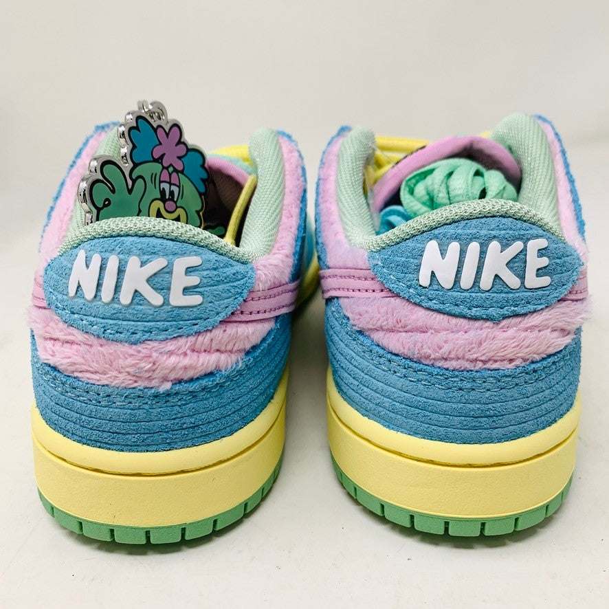The 100% authentic Nike SB Dunk Low Verdy Visty (PS) sneaker showcases blue, pastel yellow, pink, and mint green accents with textured fabric and a pink swoosh. It is displayed atop a white Nike SB shoebox.