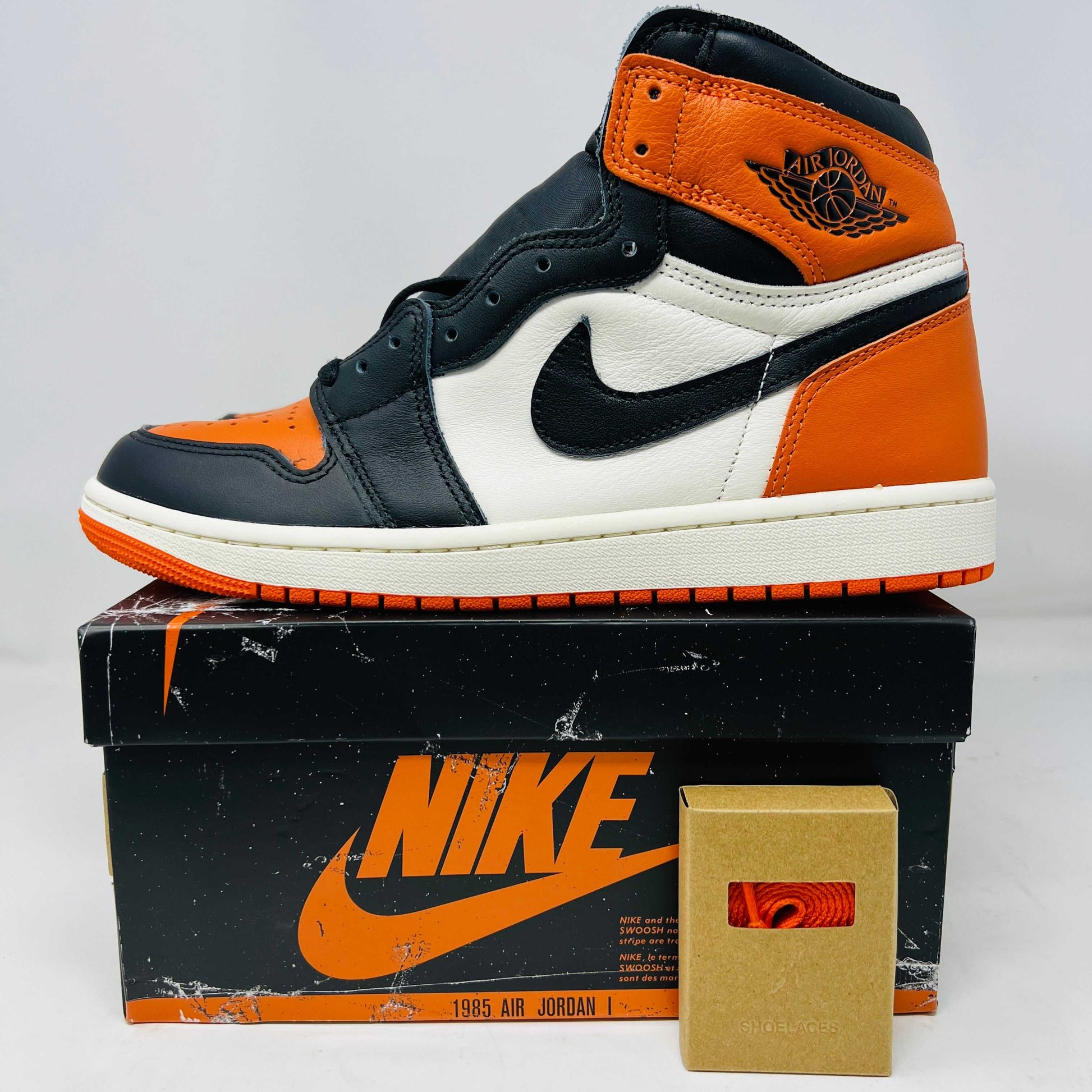 Jordan 1 Retro High OG Shattered Backboard sneaker in black and orange on Nike box with extra laces 2025 edition