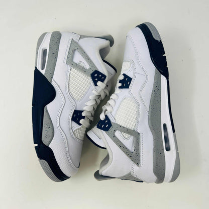 A brand new Jordan 4 Retro Midnight Navy (GS) sneaker from 2022 sits atop a red Nike shoe box with the iconic swoosh, featuring a white and gray design, leather and mesh mix, dark blue accents, and a visible air unit in the sole.