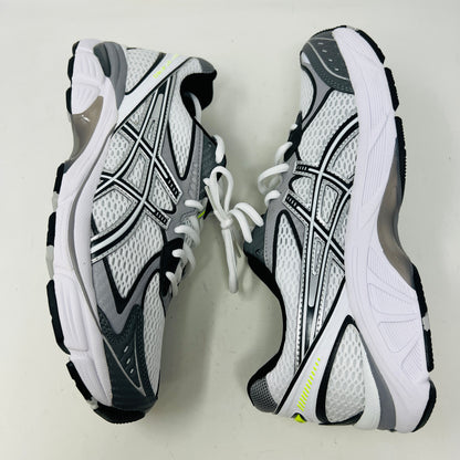 A brand new pair of ASICS GT-2160 JJJJound White sneakers, featuring mesh details and black stripes, is displayed on a black ASICS shoe box with extra laces in front for a complete authentic look.