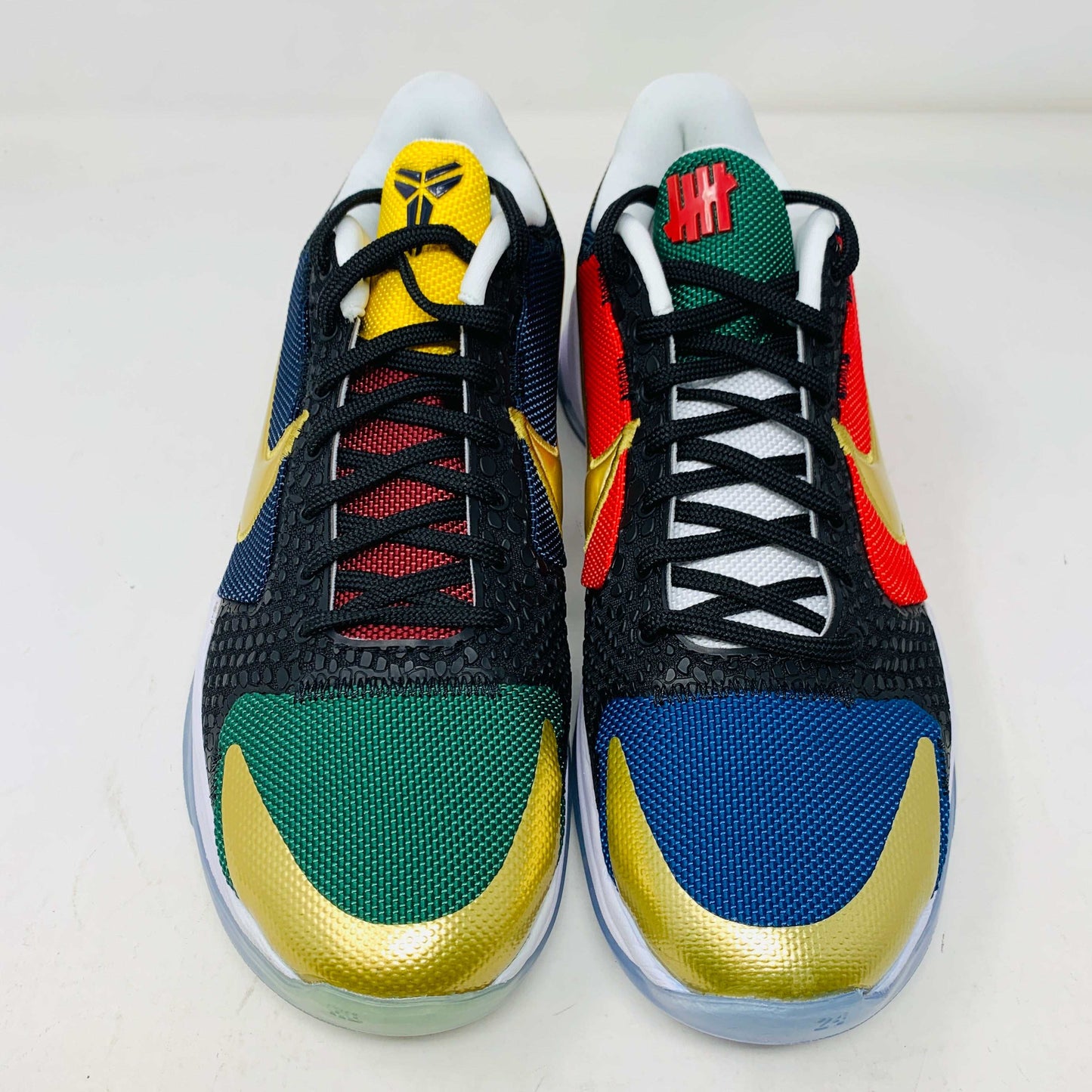 Kobe V Protro Undefeated Pack sneakers in black, gold, purple, and bold multi-color designs.