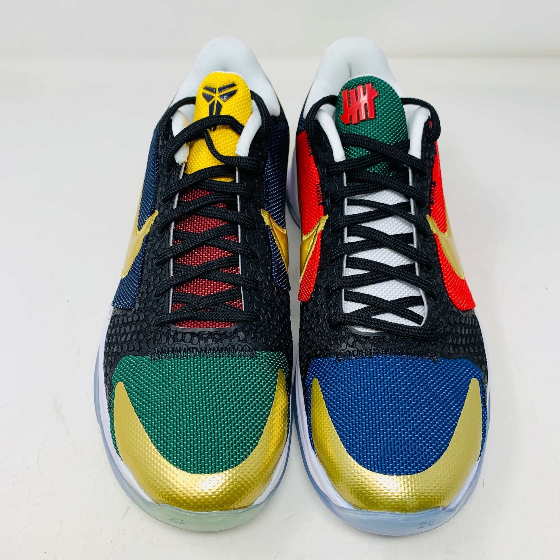 Kobe V Protro Undefeated Pack sneakers in black, gold, purple, and bold multi-color designs.