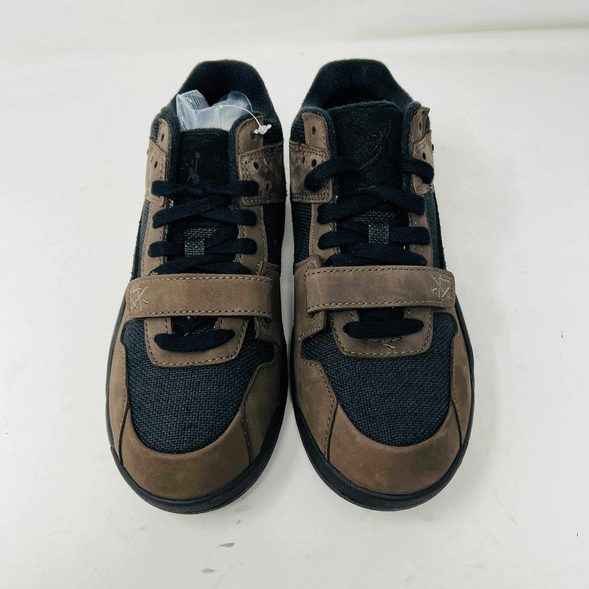 The Jordan Jumpman Jack TR Travis Scott Dark Mocha (PS) sneakers feature a mix of brown and black colors, velcro straps, and laces set on a white background.
