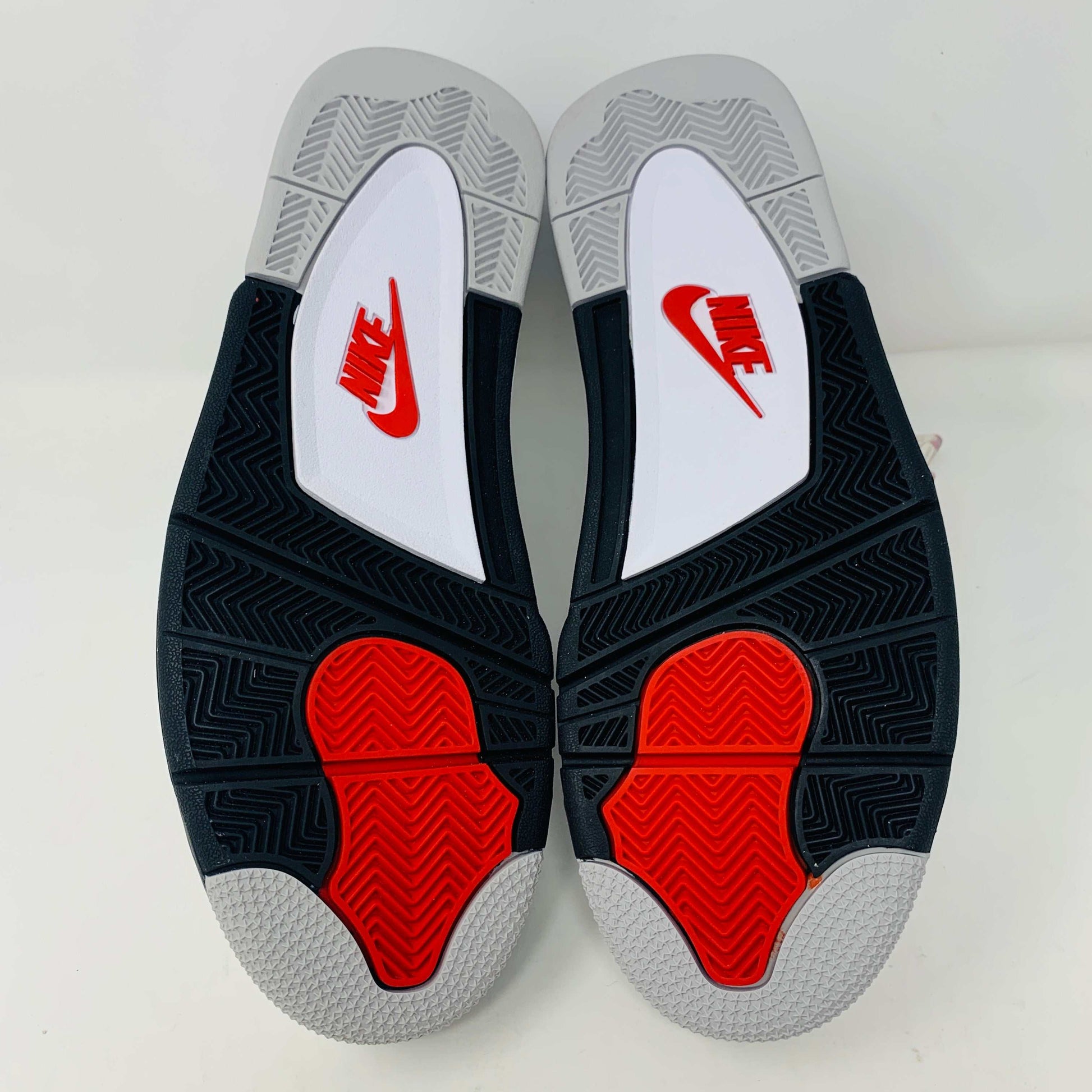 Check out the Jordan 4 White Cement 2016, a white sneaker with black and gray speckles. It features a small red jumping logo, comes in a matching box, and includes the classic 2016 Jordan hang tag for authenticity.