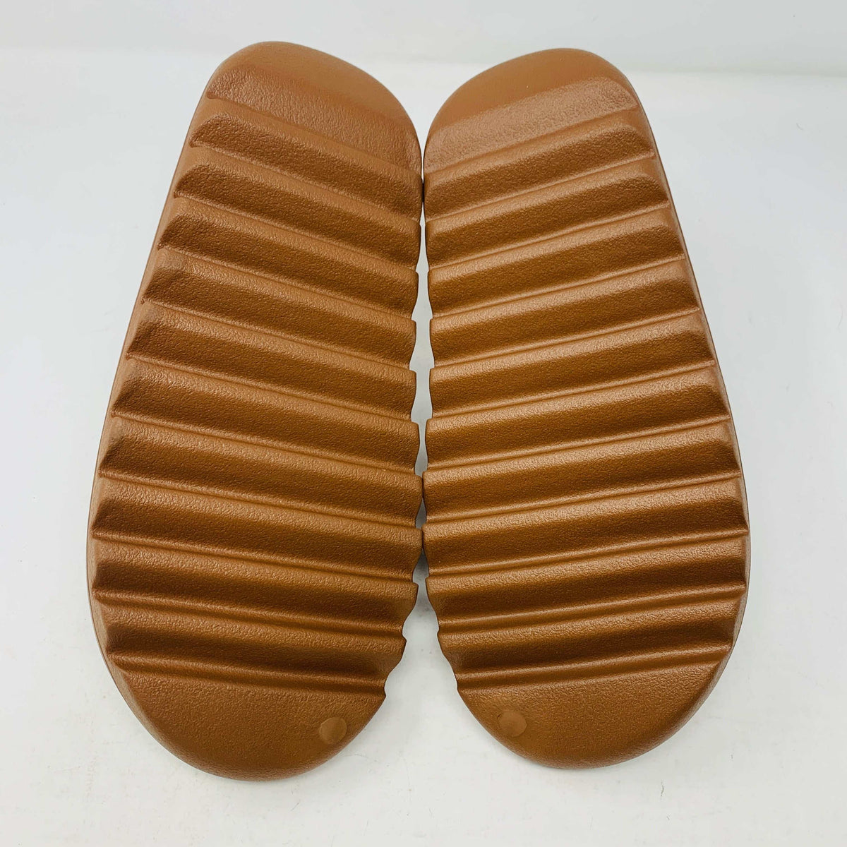 Yeezy Slide Flax with textured sole in neutral color.