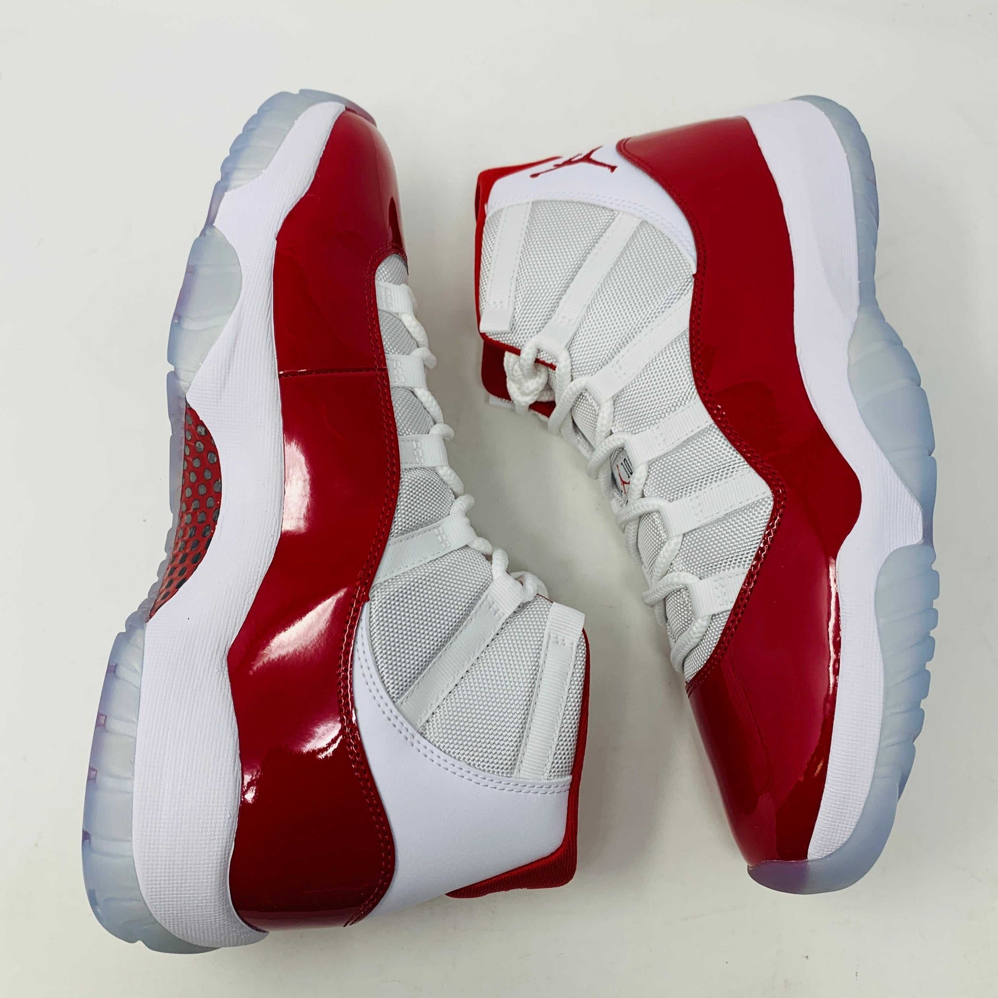 Jordan 11 Retro Cherry 2022 sneakers in white and red with leather and mesh upper, patent leather accents, and full-length Air-Sole unit.