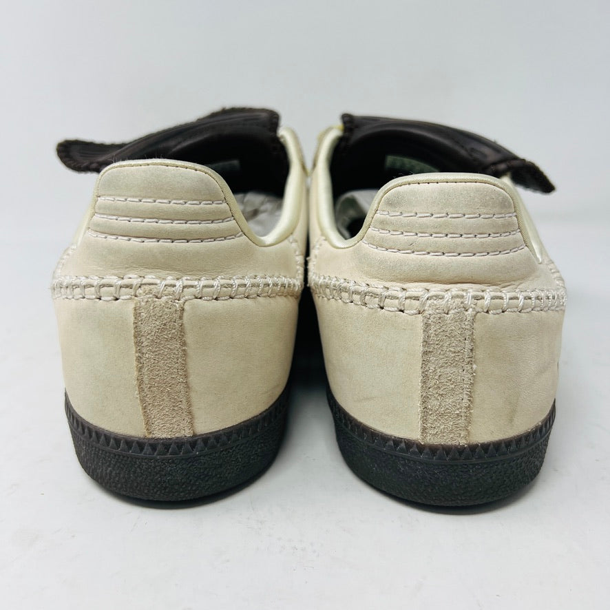 The 2023 adidas Samba Wales Bonner Ecrtin Brown sneakers feature beige uppers with three yellow stripes, a brown logo flap, and black soles. Despite general wear, the side and tongue branding stays distinct. Theyre displayed side by side on a white background.
