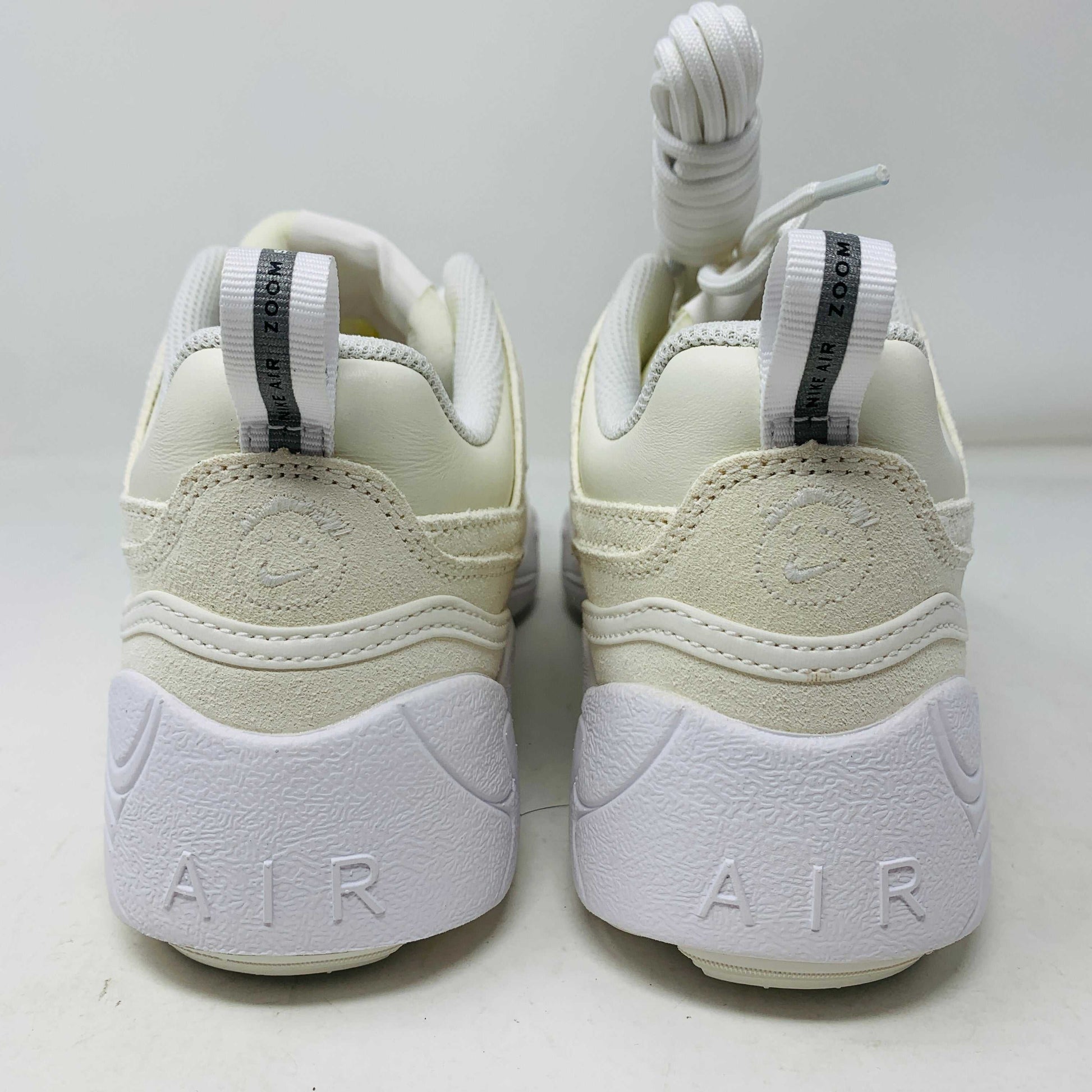 A pair of brand new, 100% authentic Nike Zoom Field Jaxx SP Travis Scott Sail sneakers feature a white colorway with a textured design and lace-up closure. The shoes, shown on a white background, have a thick sole and combine smooth and perforated panels.
