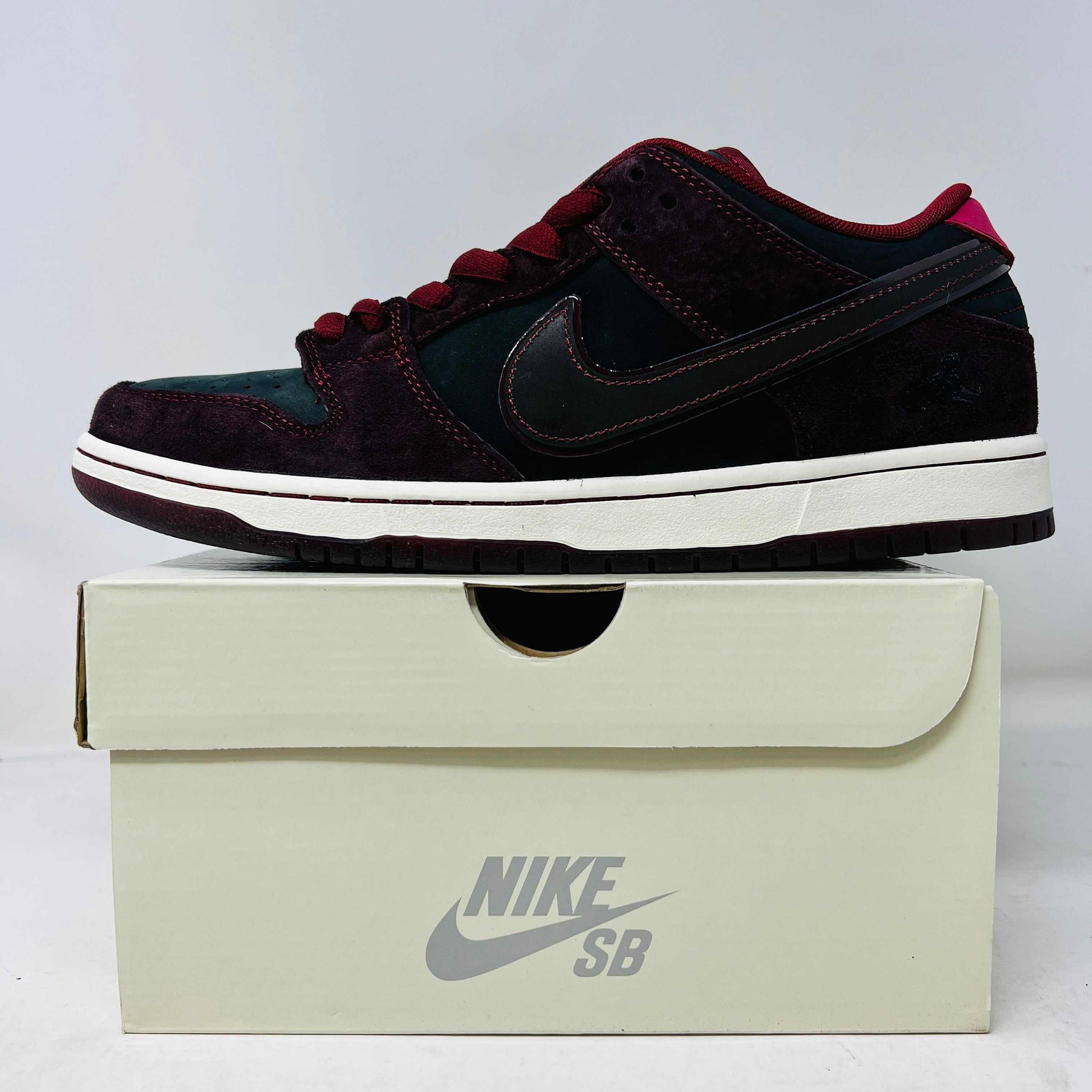 Nike SB Dunk Low Riot Skateshop sneaker in brand new condition with extra laces, displayed on a Nike SB box.
