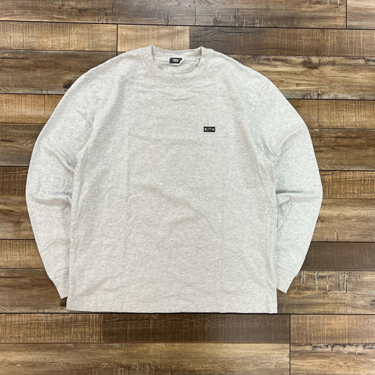Kith Long Sleeve Lax Tee in light heather grey laid flat on wooden floor preowned