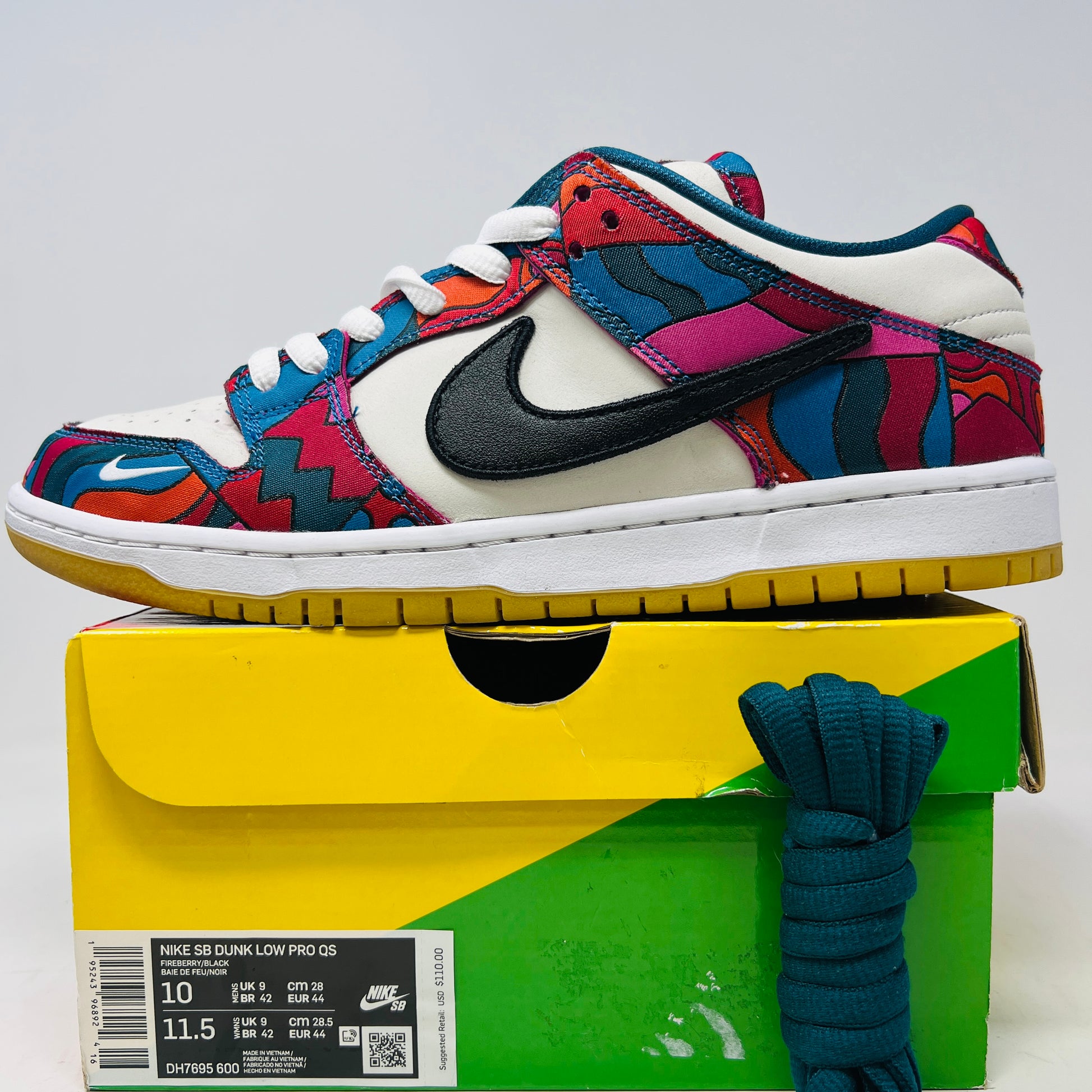 The Nike SB Dunk Low Pro Parra Abstract Art (2021) features a colorful design with abstract red, blue, and purple patterns on a white base. It includes clean uppers with a black swoosh, white laces, and comes in a green/yellow box with extra blue laces for added versatility.