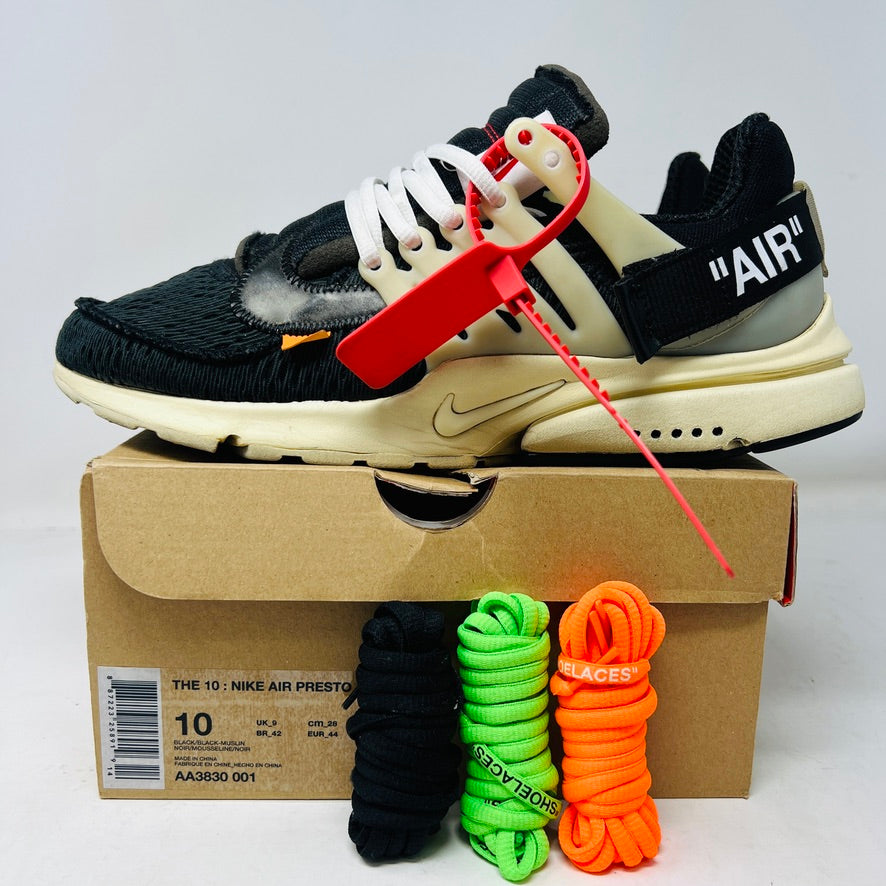 The 2017 classic Nike Air Presto Off-White features a black sneaker with white laces, a red tag, iconic AIR text, and an edgy zip tie. Displayed on its box, it includes extra black, neon green, and orange laces labeled SHOELACES.