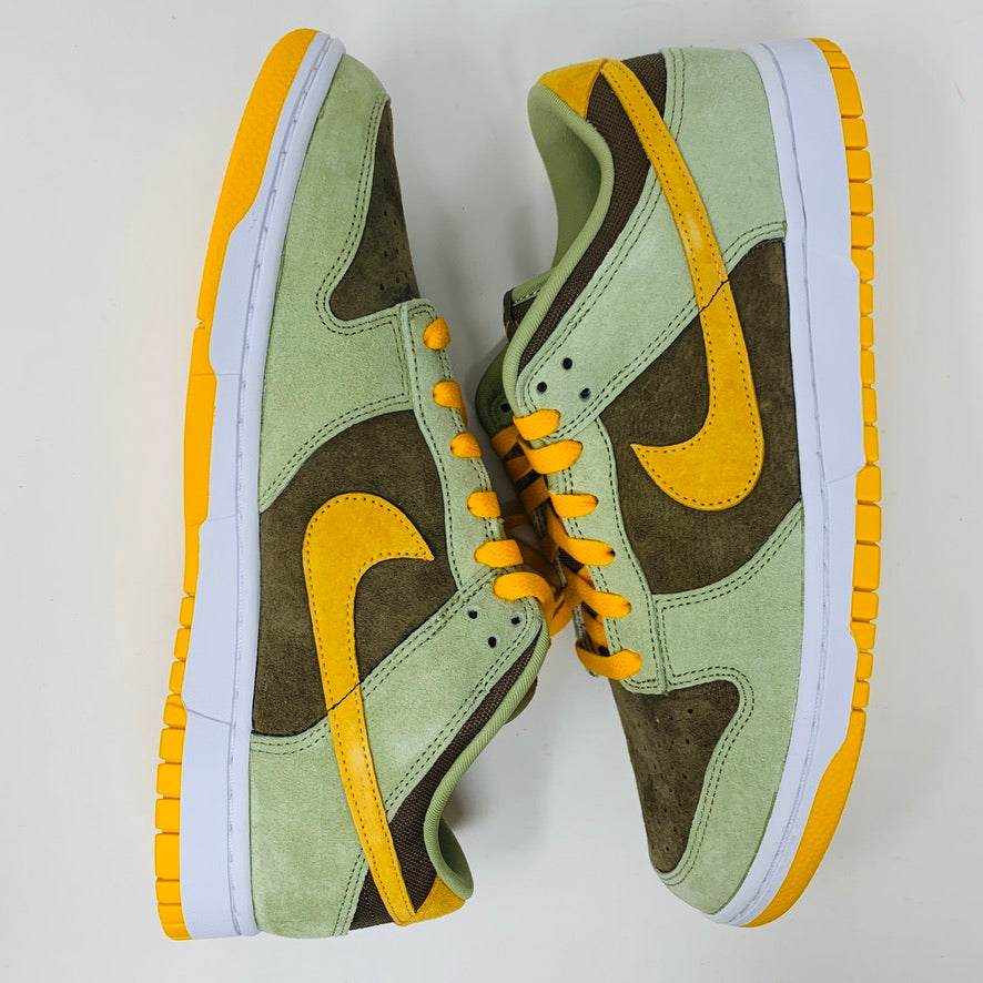 Nike Dunk Low Dusty Olive sneakers on an orange box.