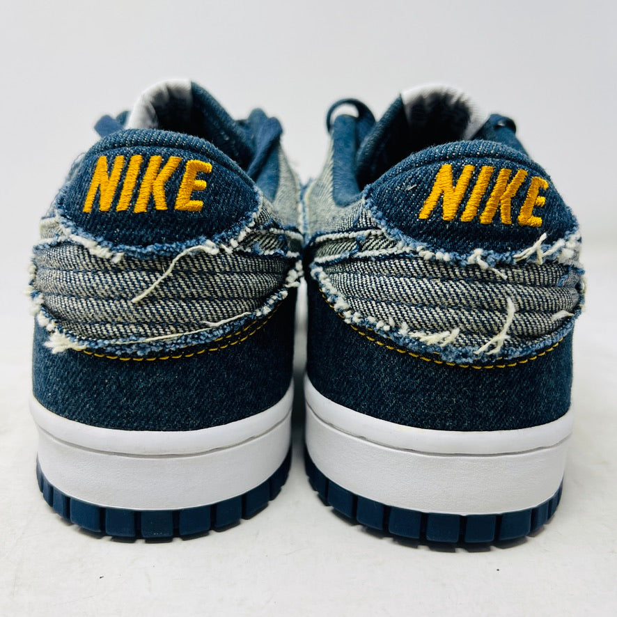 Side view of a brand new Nike Dunk Low CL Denim sneaker with white accents, resting on its orange box. A label reads Denim Dunk. Released in 2006, it features a textured design with a white midsole and blue outsole. Box condition is pristine. Brand: Nike.