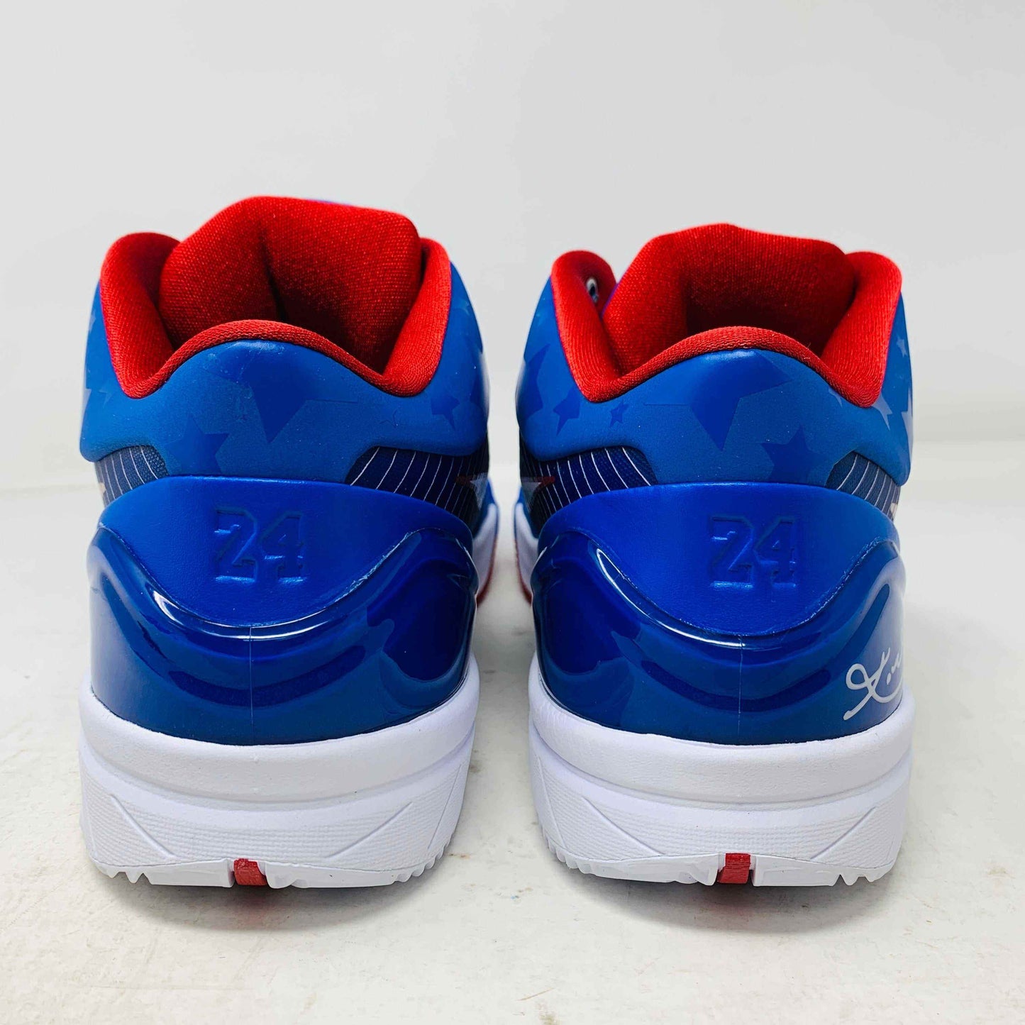 The Nike Kobe 4 Protro Philly (2024) sneakers feature blue uppers, red interiors, and white soles with star patterns. Number 24 and a signature on the heels complete their iconic look, all presented against a crisp white background.