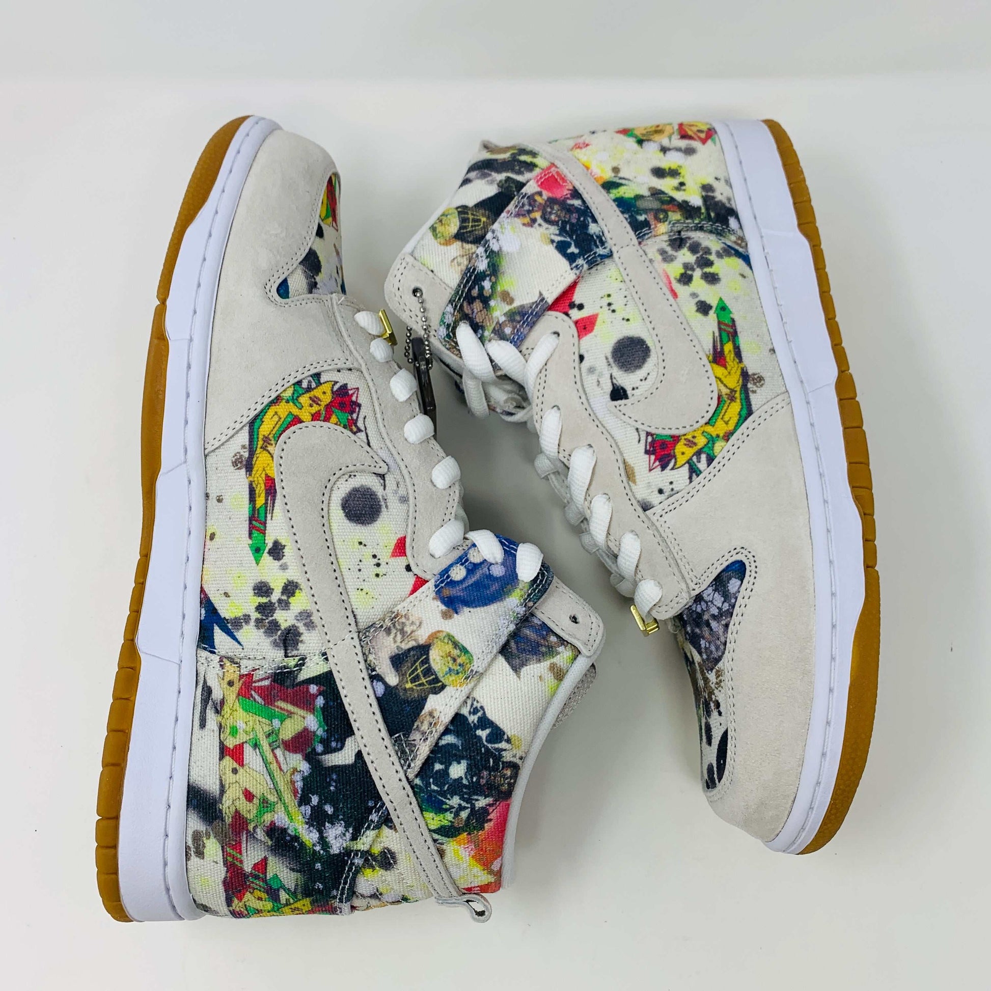 The Nike SB Dunk High Supreme Rammellzee, a 2023 release, sports a vibrant, abstract design. It features an off-white upper with a gum sole and sits atop a Nike SB shoe box. A World Famous tag affirms authenticity, making it ideal for collectors and enthusiasts.