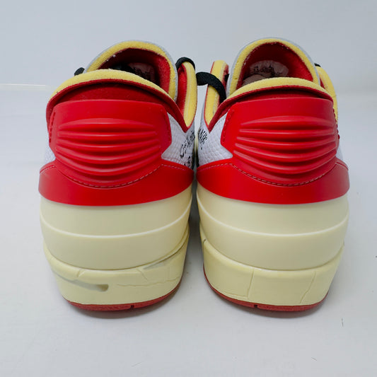 The Jordan 2 Retro Low SP Off-White White Red sneakers feature a rear view with black laces, bold red ribbed heels, cream midsoles, and yellow inner linings against a neutral background.