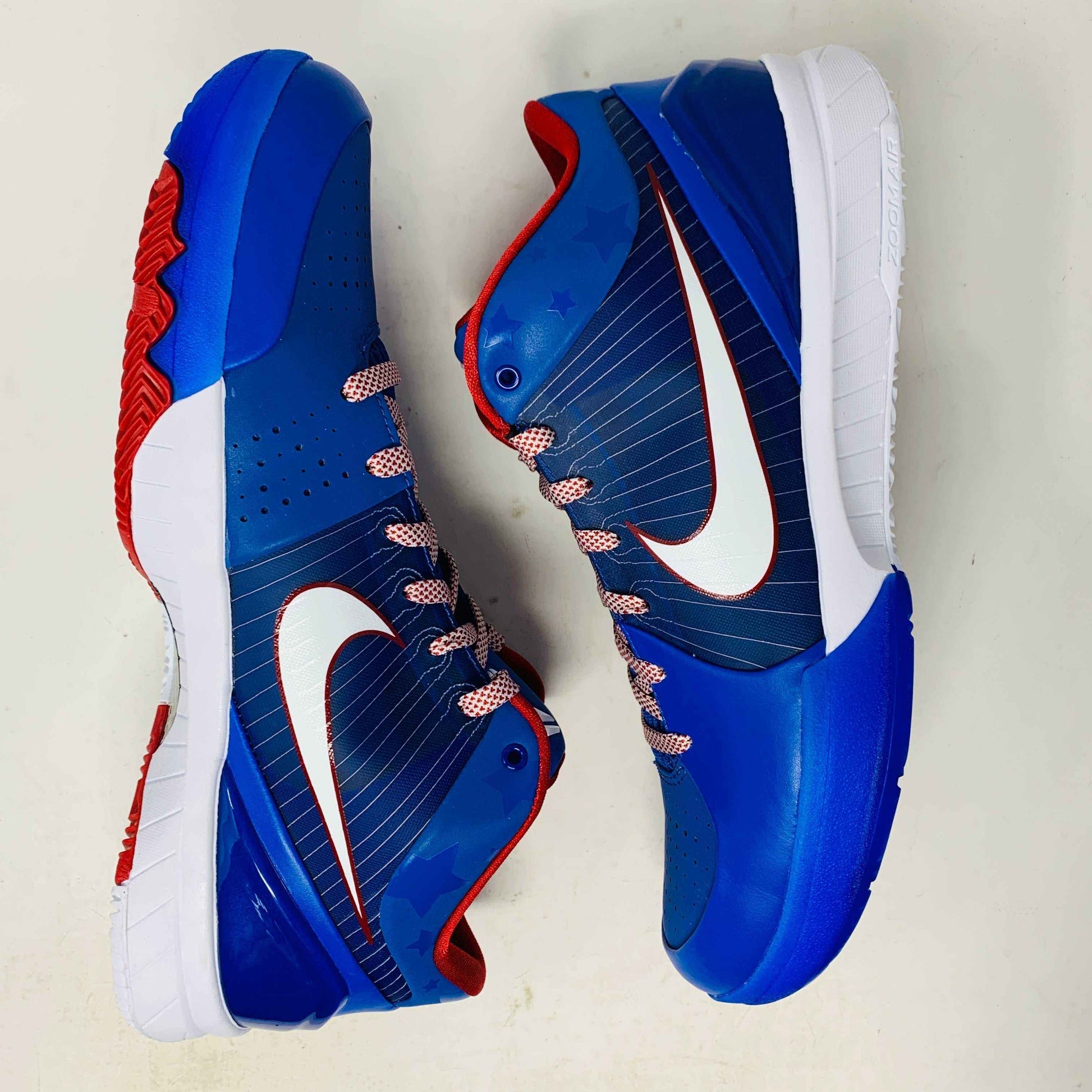 The Nike Kobe 4 Protro Philly (2024) sneakers are blue with white soles, red accents, and swooshes. These basketball shoes feature red/white laces and star patterns on the upper sides, honoring Philadelphia. Displayed on a white background.