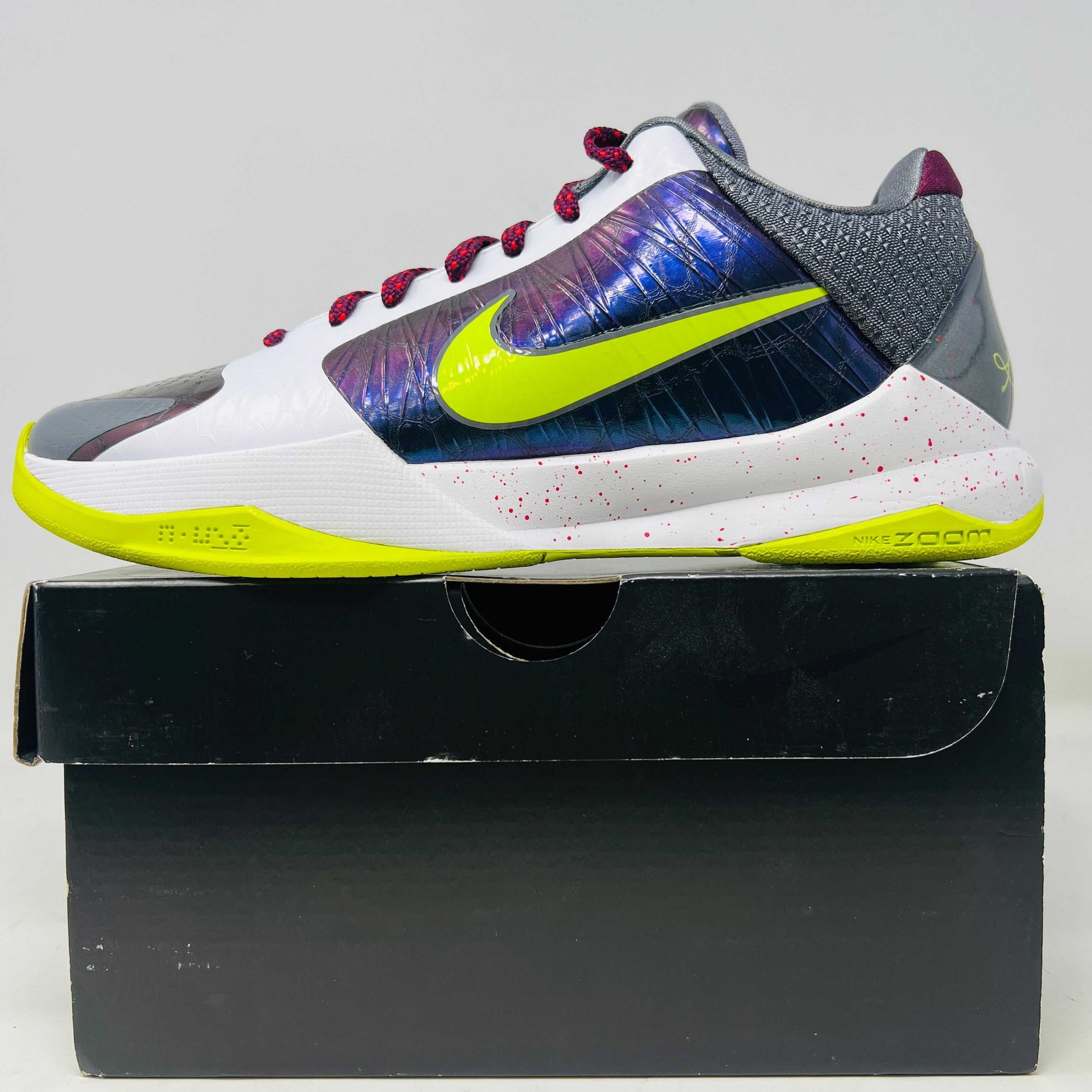 Nike Kobe 5 Protro Chaos sneaker on a black box, highlighting bright accents.